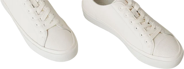 White sneakers on a white floor, background removed
